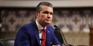 Man in blue suit speaking at a microphone