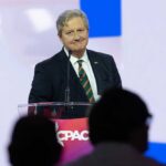 A speaker at a podium addressing an audience during a conference