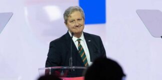 A speaker at a podium addressing an audience during a conference