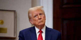 Person in suit and red tie standing indoors