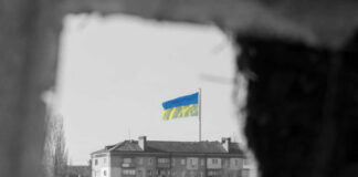 Ukraine flag on building seen through dark frame.