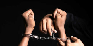 Hands in handcuffs being unlocked with key