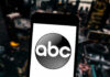 Bachelorette’s Shock Cancellation: Violence Exposed A smartphone displaying the ABC logo against a blurred urban background