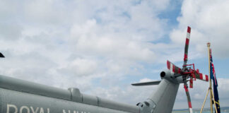 Military helicopter on a naval deck with a cloudy sky
