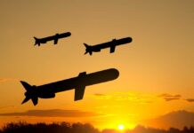 Silhouettes of missiles flying against a sunset backdrop