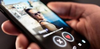 Close-up of a hand holding a smartphone displaying a dating app interface