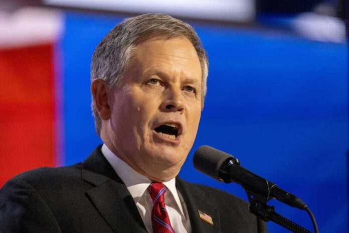 Man in formal attire speaking passionately into a microphone