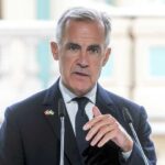 A man in formal attire speaking at a podium
