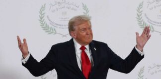 A political figure gesturing with hands during a public appearance