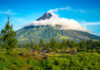 A majestic volcano surrounded by lush greenery and clouds