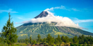 A majestic volcano surrounded by lush greenery and clouds