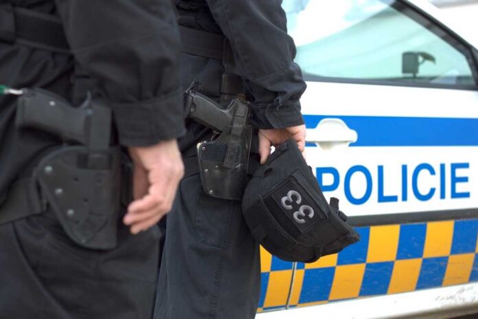 shutterstock_93727489.jpg Two police officers standing near a patrol car