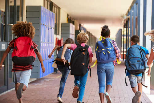 school735954742 Children running with backpacks in a school corridor
