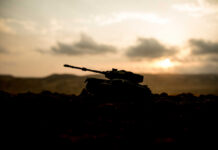 Silhouette of a tank against a sunset backdrop