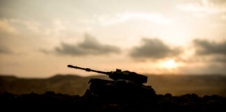 Silhouette of a tank against a sunset backdrop
