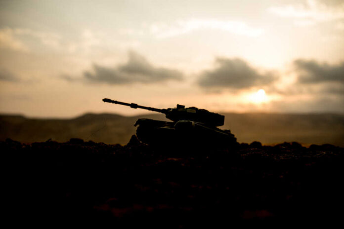 Silhouette of a tank against a sunset backdrop