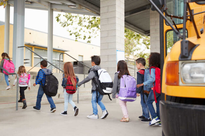Group of children walking towards a school bus
