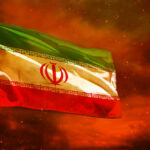 Iranian flag waving against a dramatic orange sky