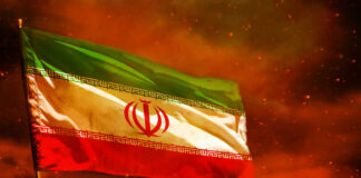 Iranian flag waving against a dramatic orange sky