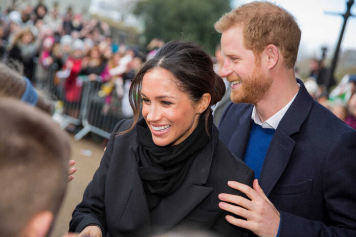 shutterstock_1559827334.jpg A smiling couple interacting with a crowd during a public event