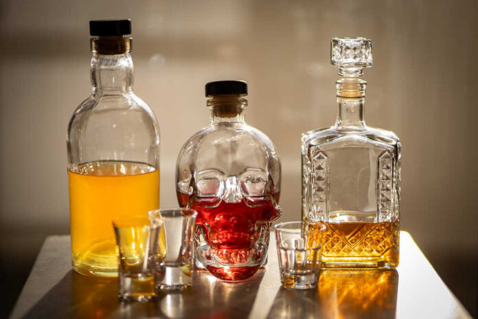 A collection of decorative liquor bottles and shot glasses on a table