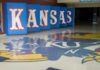 Kansas Coach’s Health Scare Sparks Fear Kansas logo displayed on the floor of a sports venue