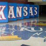 Kansas logo displayed on the floor of a sports venue