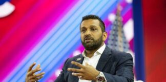 A speaker gesturing while discussing on stage at a conference