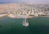Somaliland’s Risky Gamble: U.S. Base vs. Iran’s Threats Aerial view of a coastal town with fishing boats and residential buildings