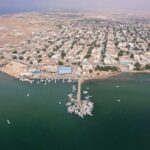 Aerial view of a coastal town with fishing boats and residential buildings