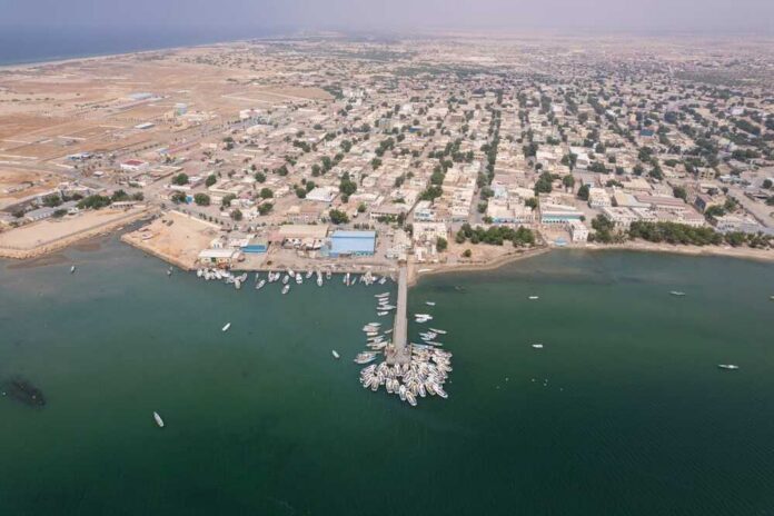 Aerial view of a coastal town with fishing boats and residential buildings