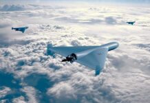 Three drones flying above the clouds in a clear sky