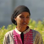 A woman in traditional attire smiling outdoors