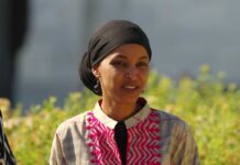 A woman in traditional attire smiling outdoors