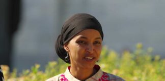 A woman in traditional attire smiling outdoors