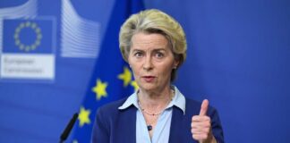 A female leader giving a thumbs up during a press conference