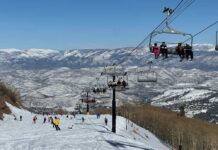 Skiers on a snowy slope with a chairlift in the background