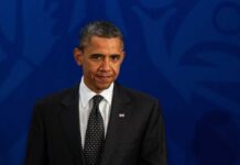 A political figure in formal attire with a serious expression