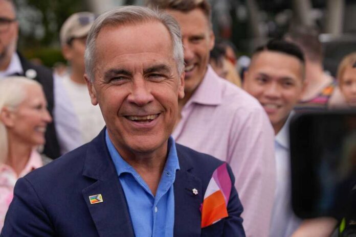 A smiling man in a blue suit surrounded by a diverse crowd at an outdoor event