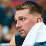 Close-up of a basketball player with a towel around his neck, looking focused