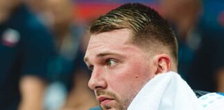 Close-up of a basketball player with a towel around his neck, looking focused