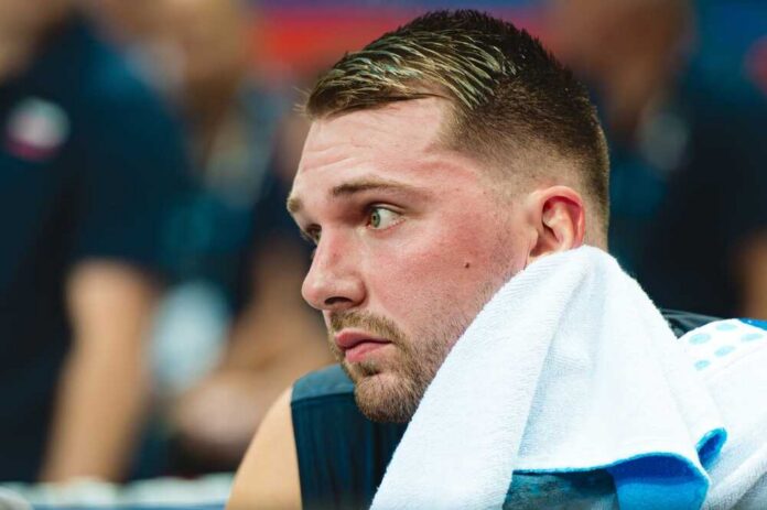 Close-up of a basketball player with a towel around his neck, looking focused