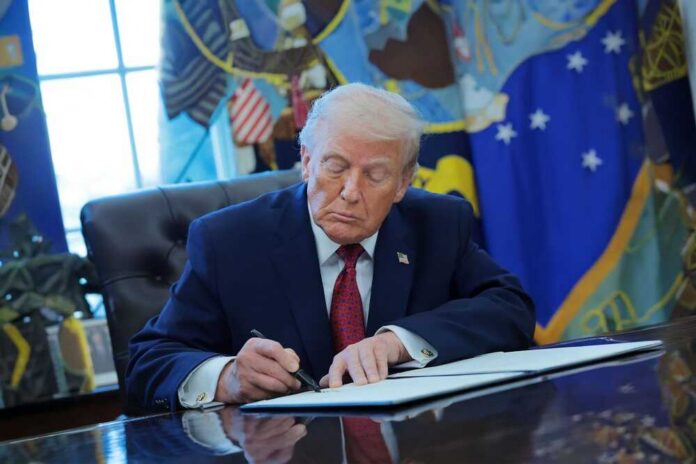 Donald Trump signing documents in the Oval Office