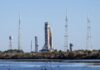 Rocket on the launch pad surrounded by communication towers and water