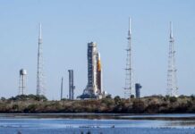 Rocket on the launch pad surrounded by communication towers and water