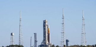 Rocket on the launch pad surrounded by communication towers and water