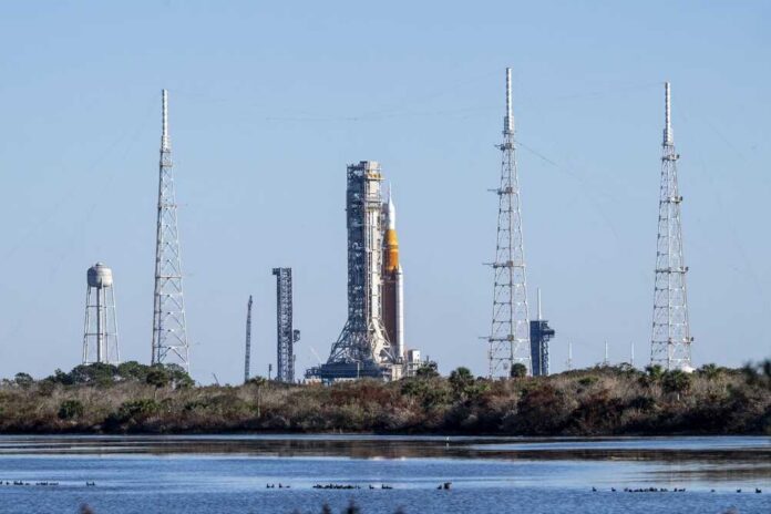 Rocket on the launch pad surrounded by communication towers and water