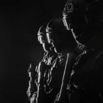 Silhouetted tactical team members in uniform with weapons