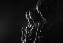 Silhouetted tactical team members in uniform with weapons