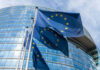 European Union flags outside modern glass building